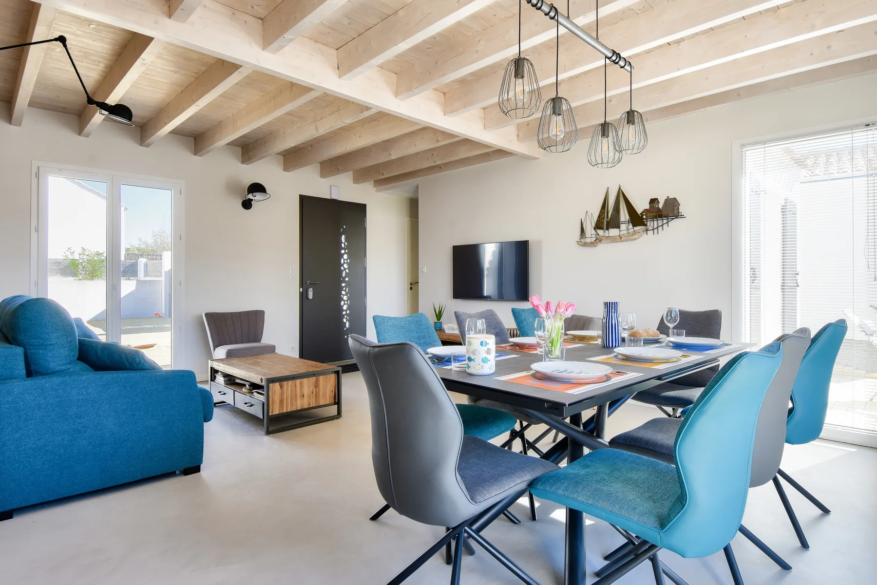 Bright living and dining area with a blue sofa and dining table.
