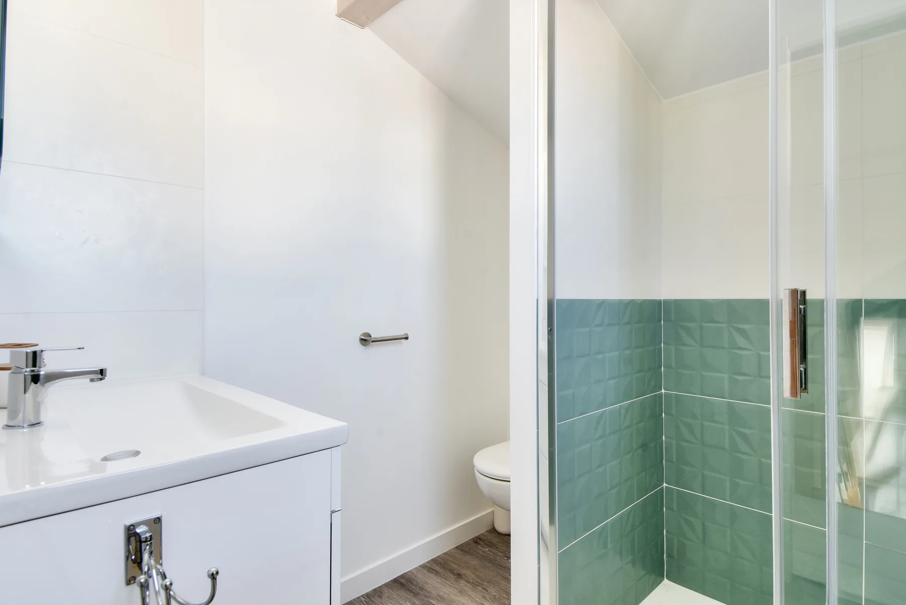 A bathroom with a sink, toilet, and glass-enclosed shower.