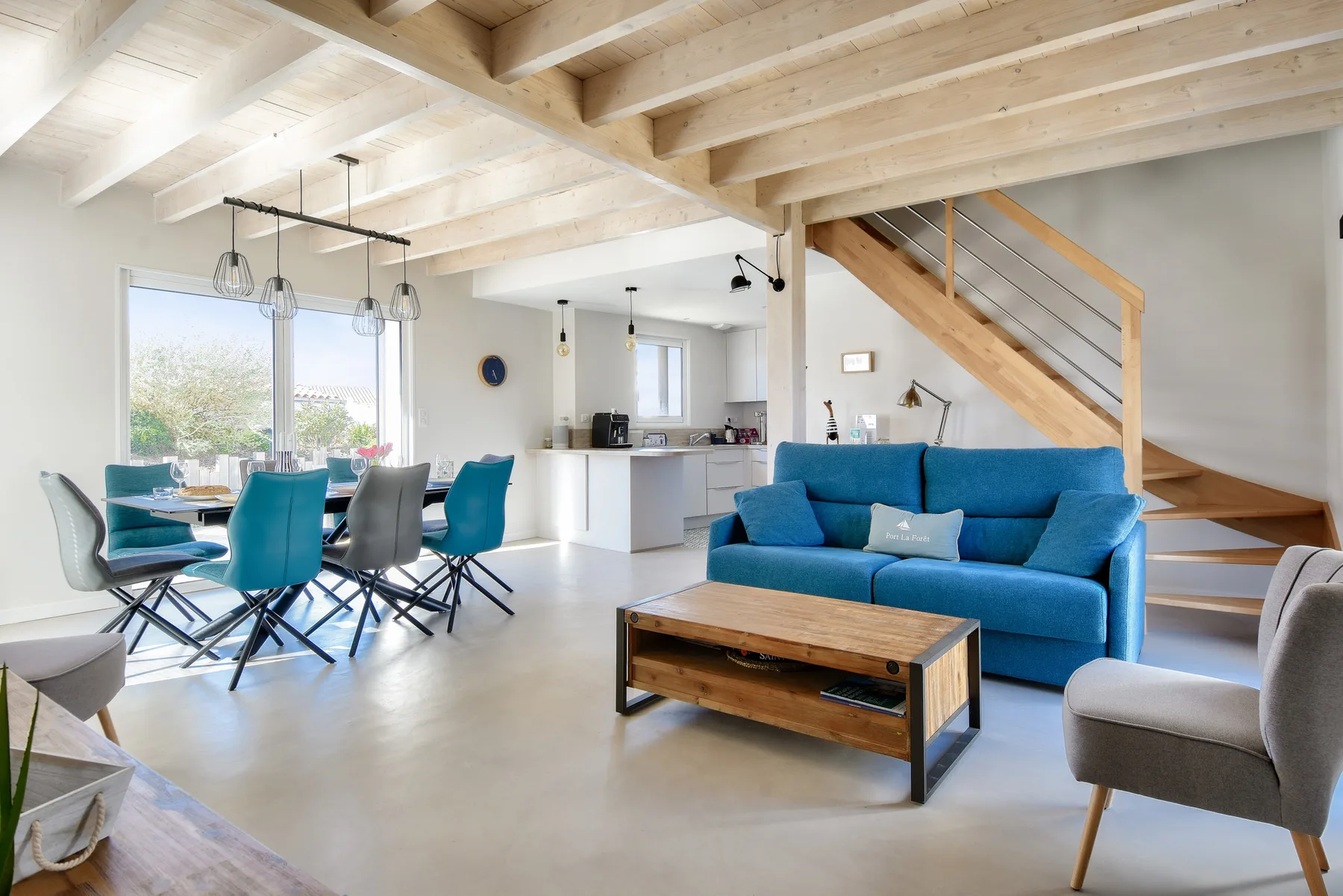 Open-plan living and dining area with a blue sofa and dining table.
