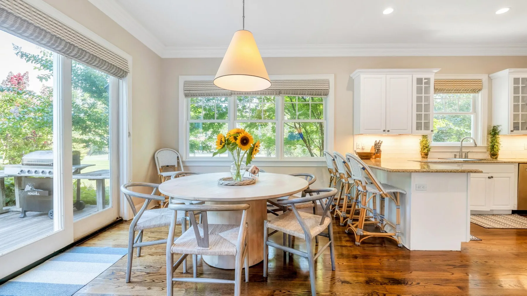 A bright dining area with a round table beside a kitchen island.