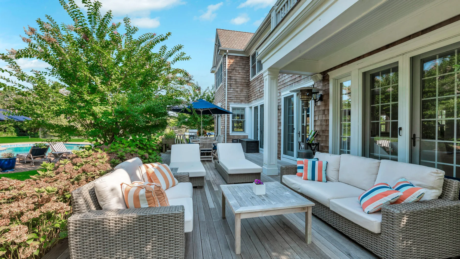 A sunny outdoor patio with cushioned seating and a low table.