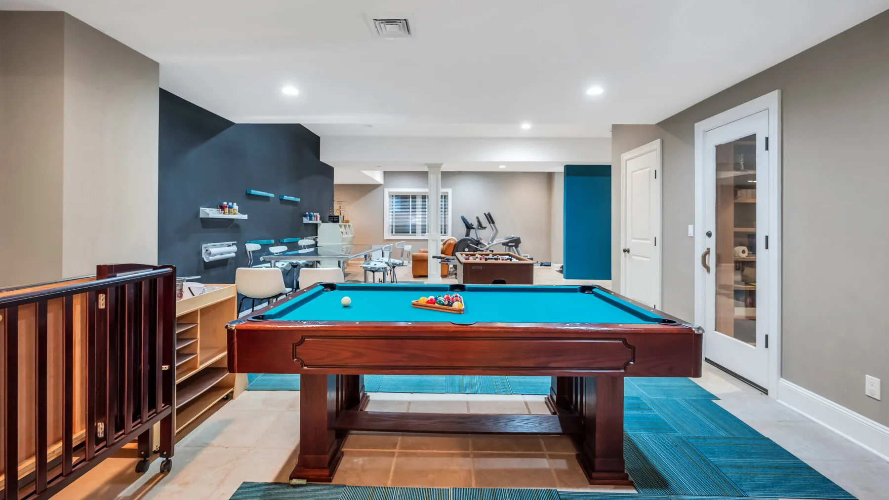 A billiards room with a pool table and cue racks along the wall.