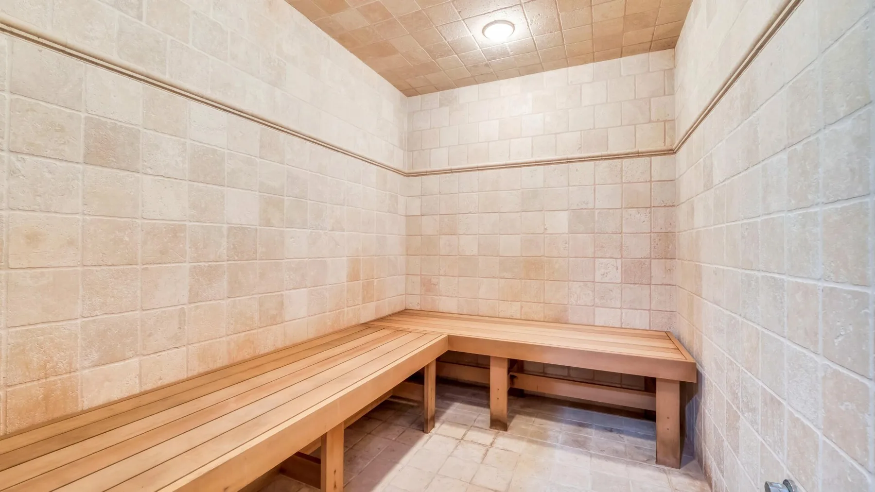A tiled room with wooden benches along the walls.