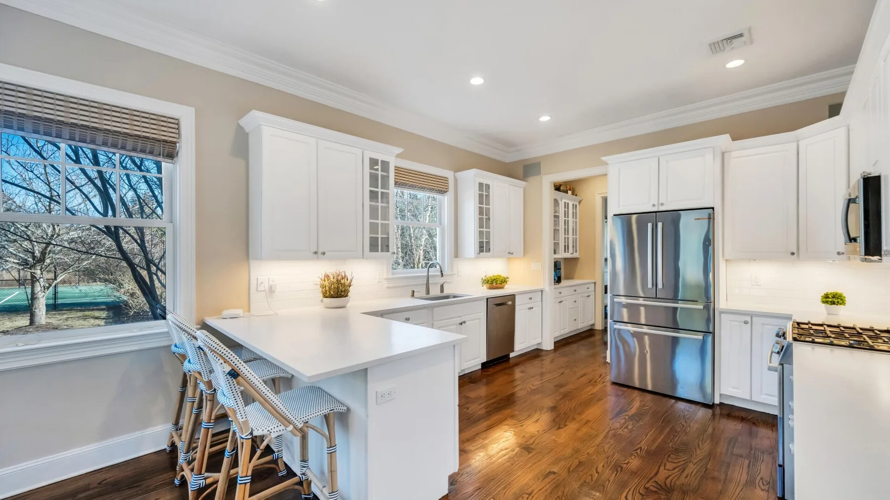 A bright kitchen with white cabinetry, a central island, and stainless-steel appliances.