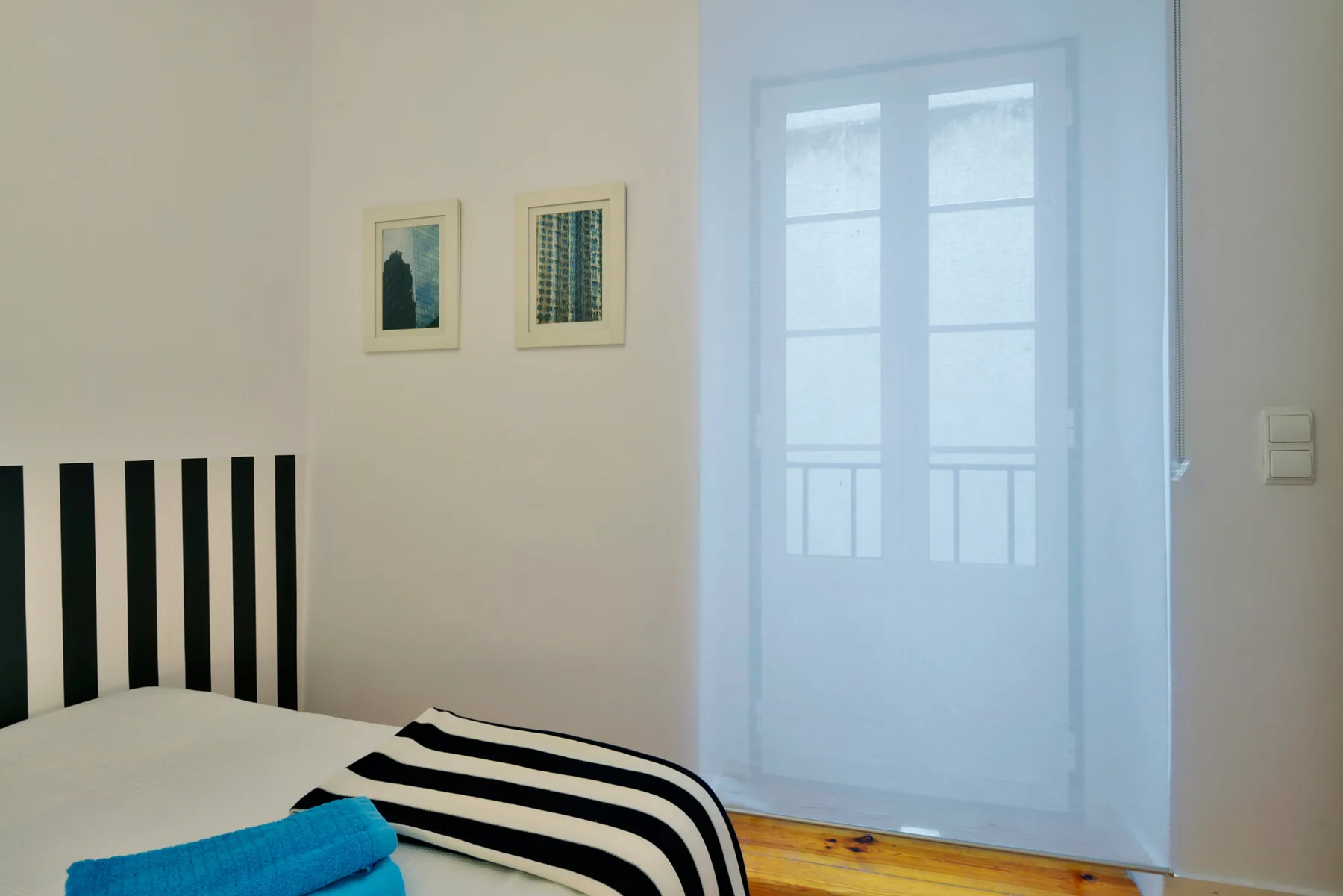 A bedroom with striped bedding and a bright window.