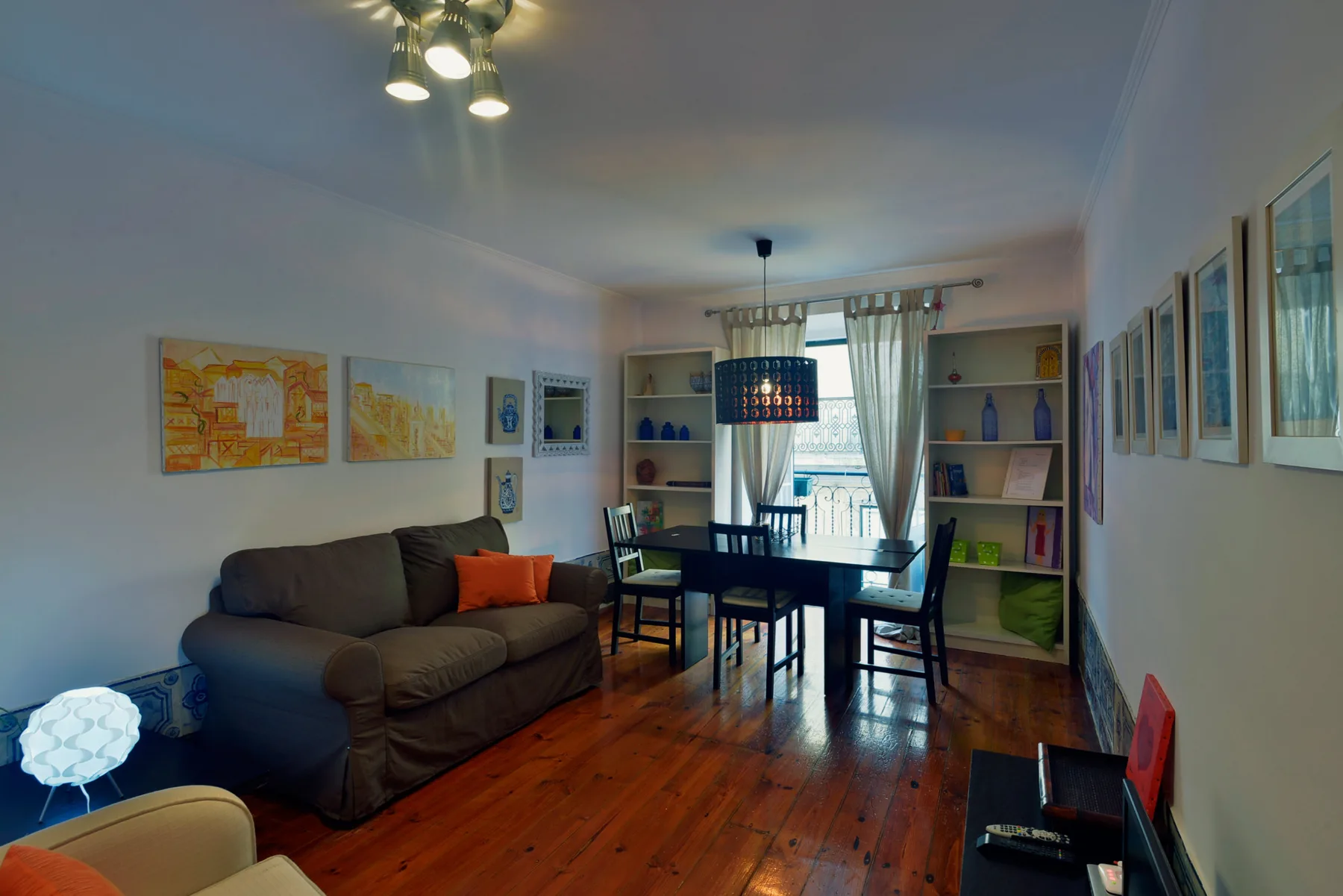 Living and dining area with a sofa, table, and wall art.