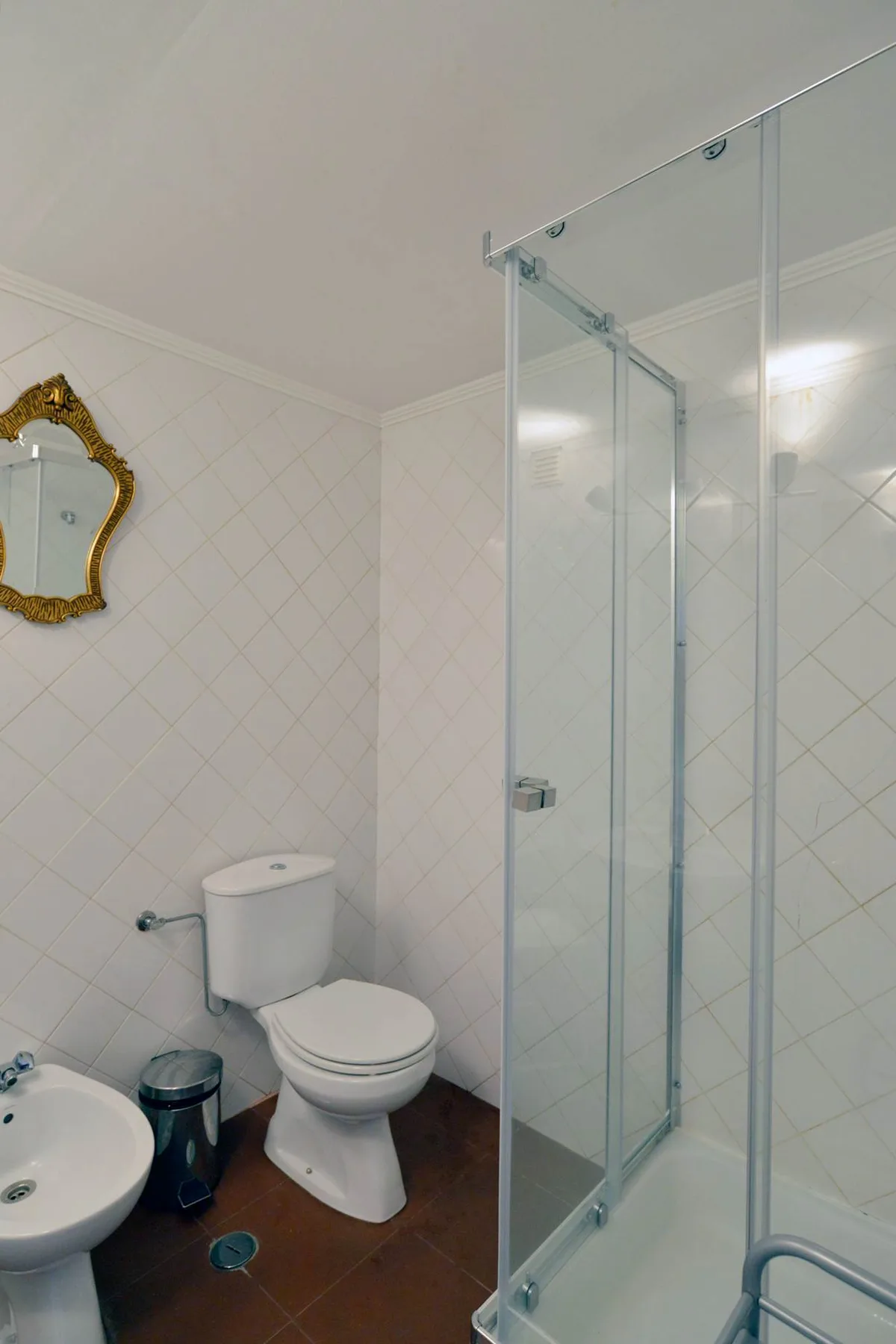 A bathroom with a toilet, sink, and glass shower.