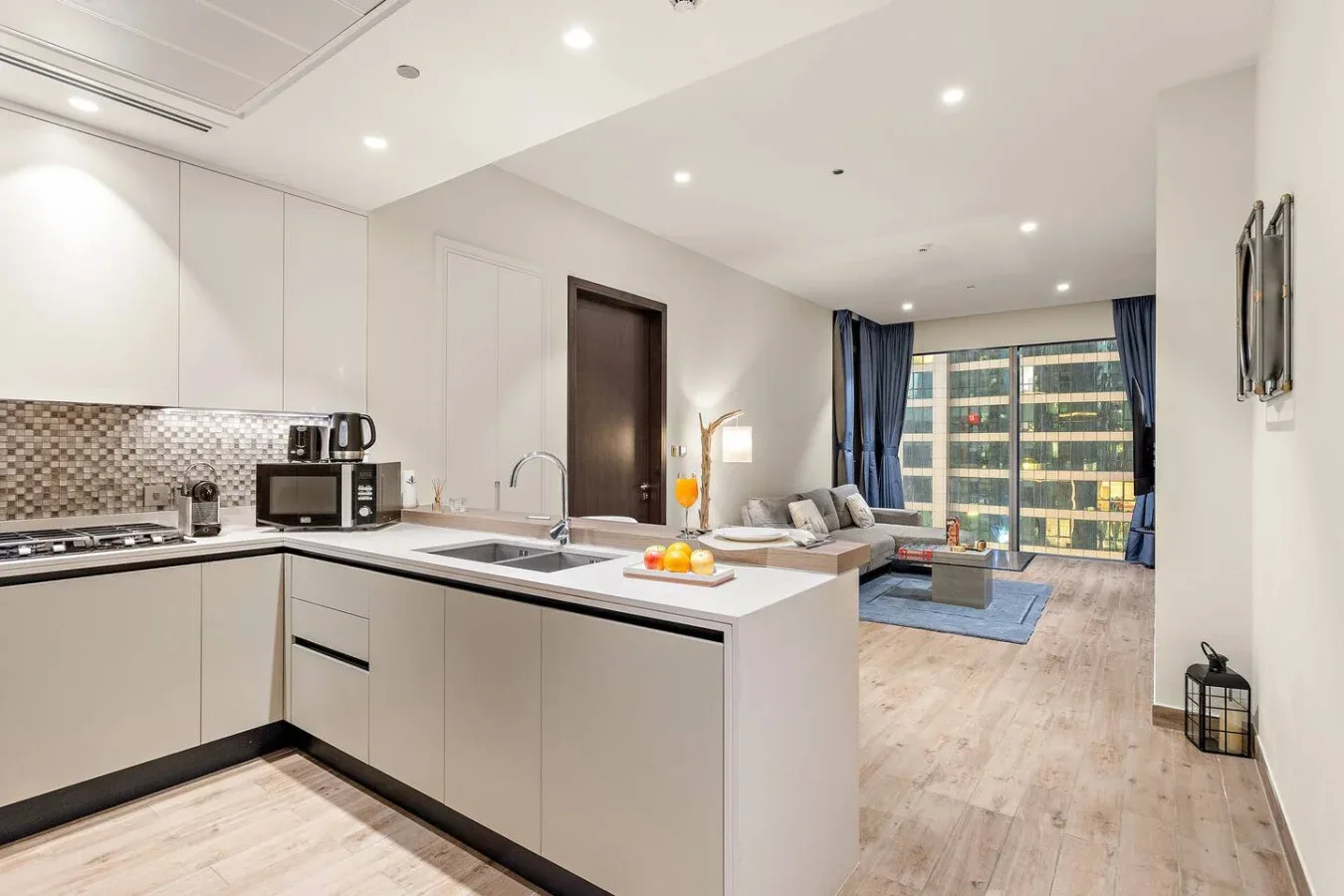 Una cocina moderna abierta al salón, con una ventana amplia.