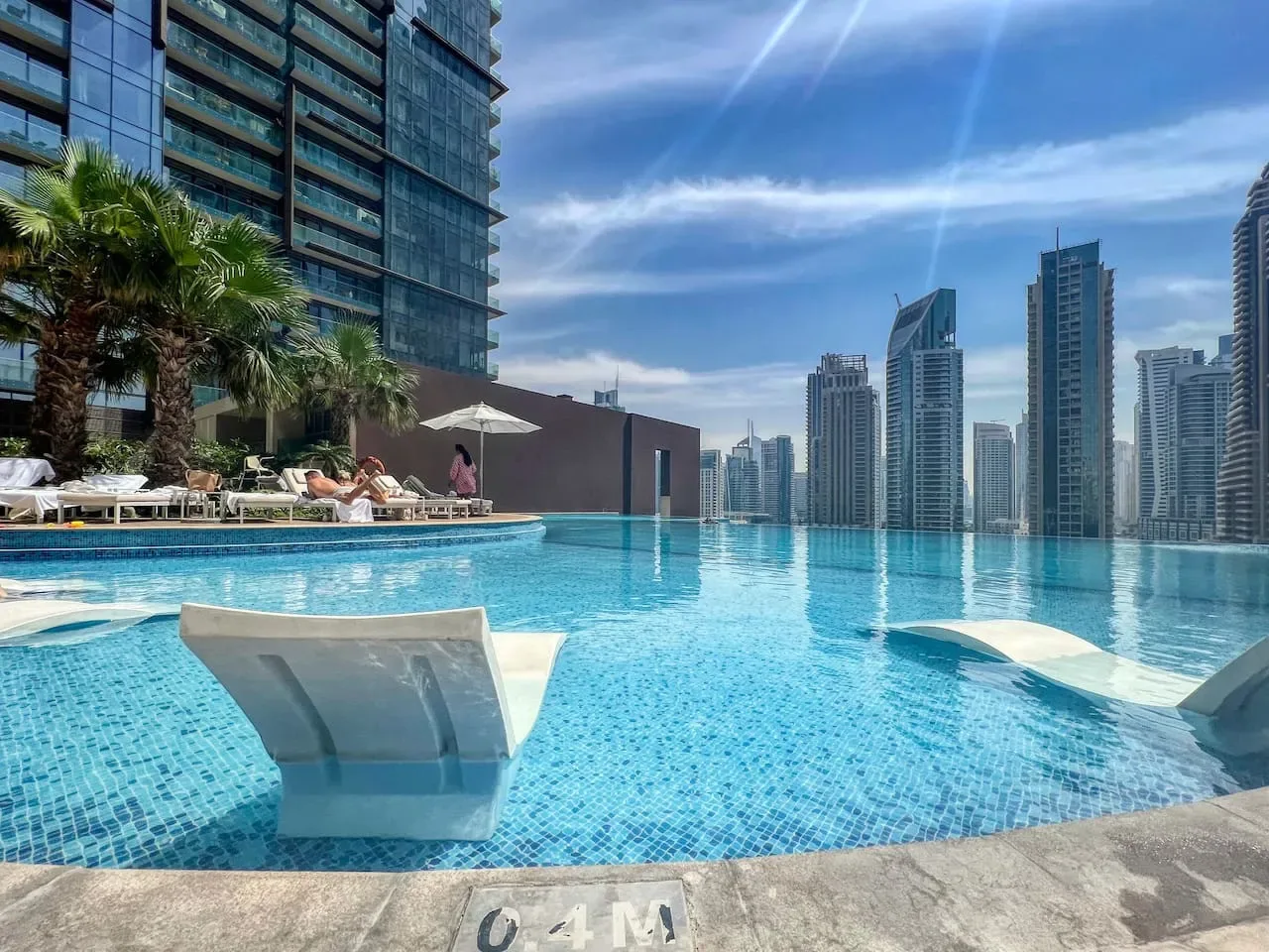 Una piscina en la azotea ofrece vistas del perfil urbano, con asientos sumergidos en el agua.