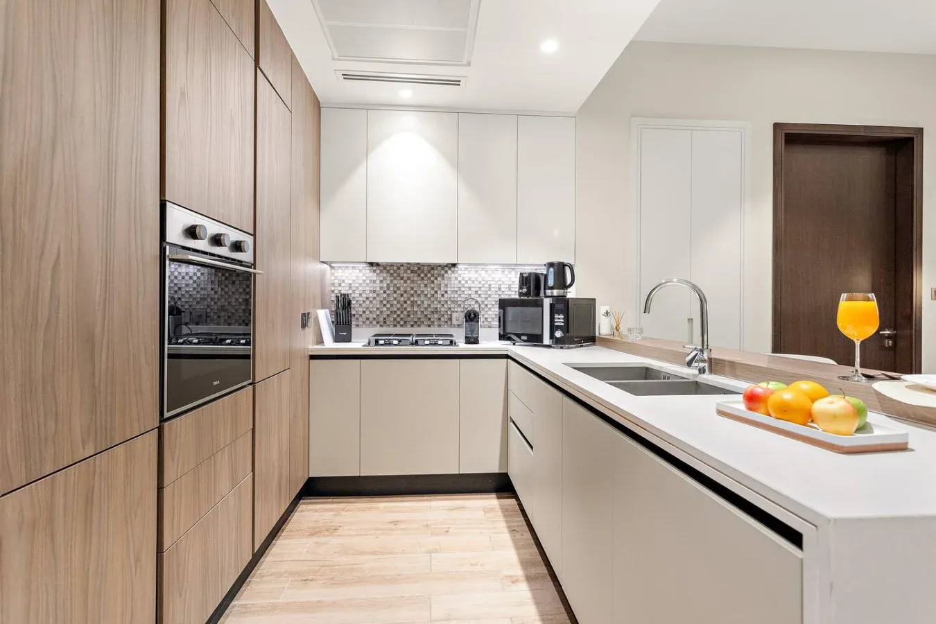 Una cocina moderna con encimera, fregadero y horno empotrado.