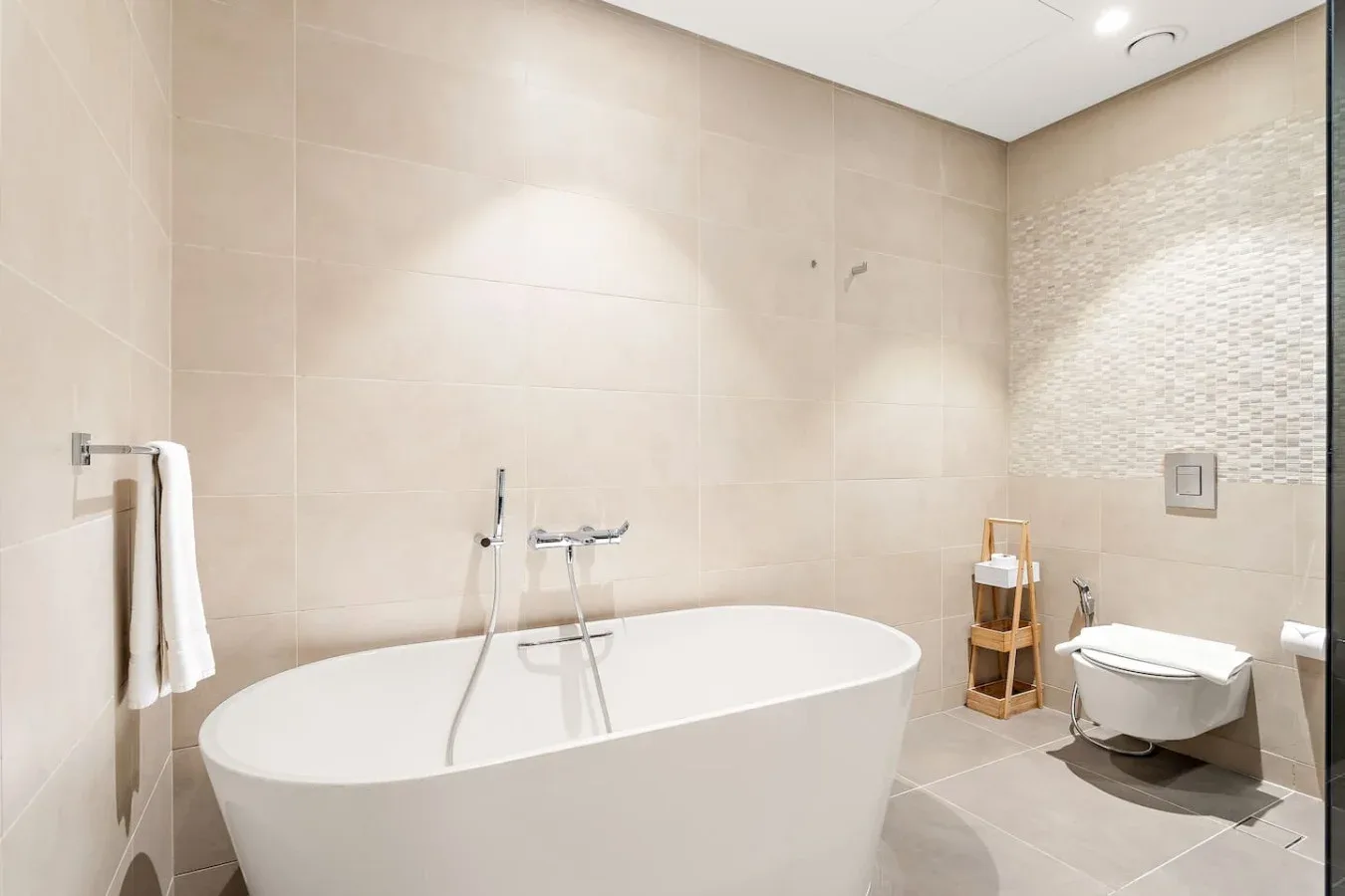 Un baño moderno con una bañera grande y un inodoro suspendido.