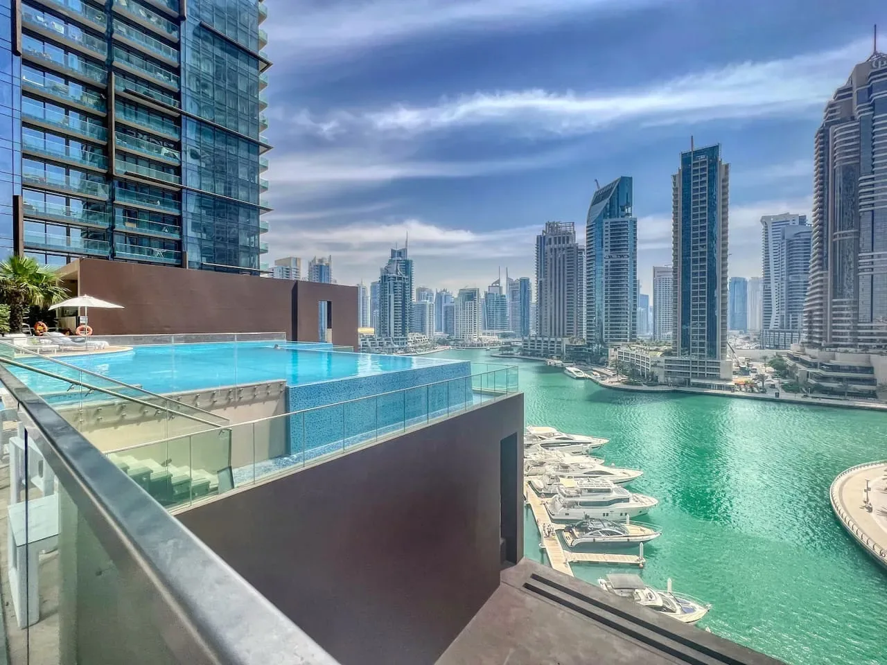 Una piscina en la azotea domina un paseo marítimo rodeado de edificios modernos.