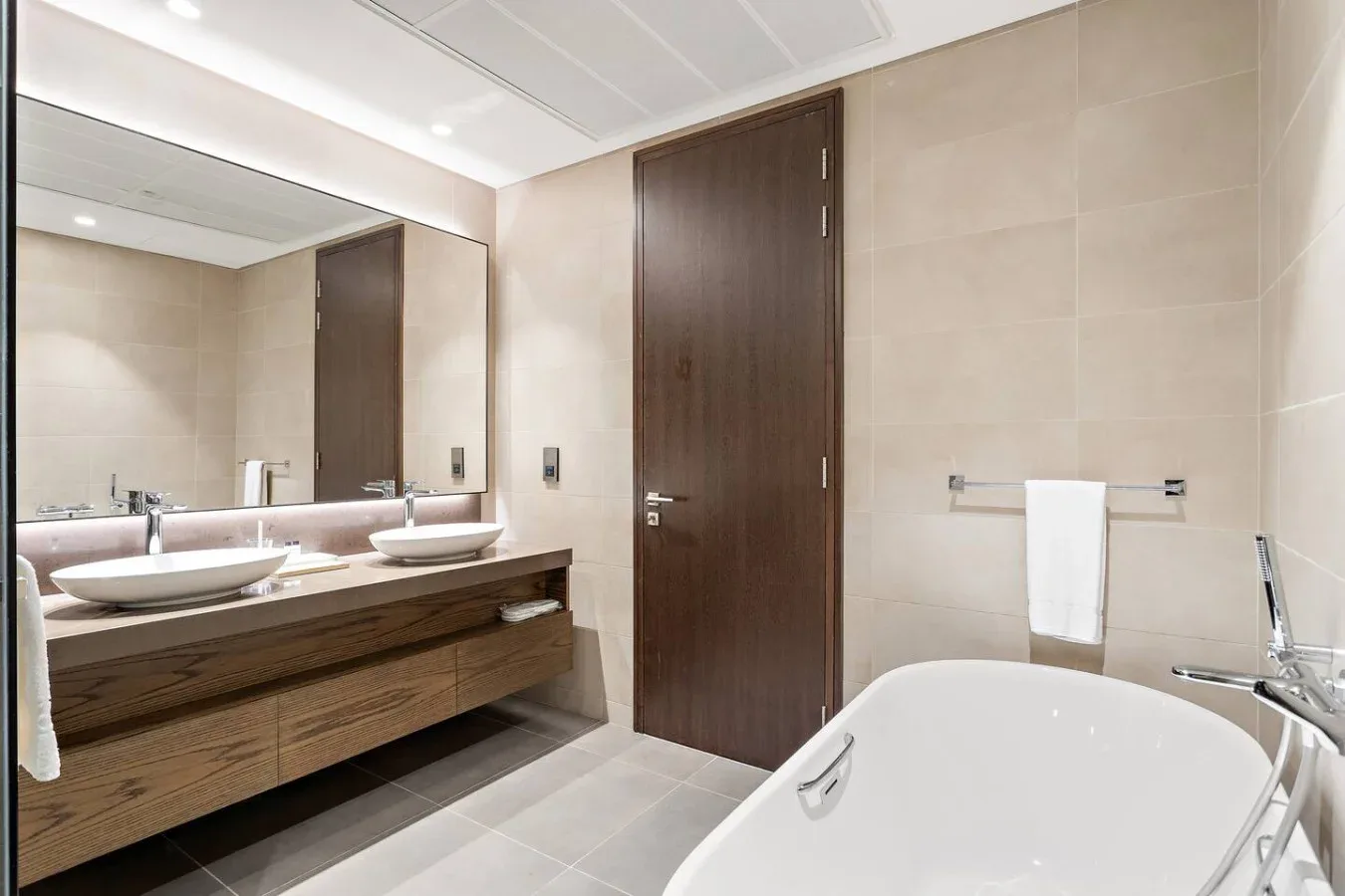 Un baño con tocador, espejo y bañera.