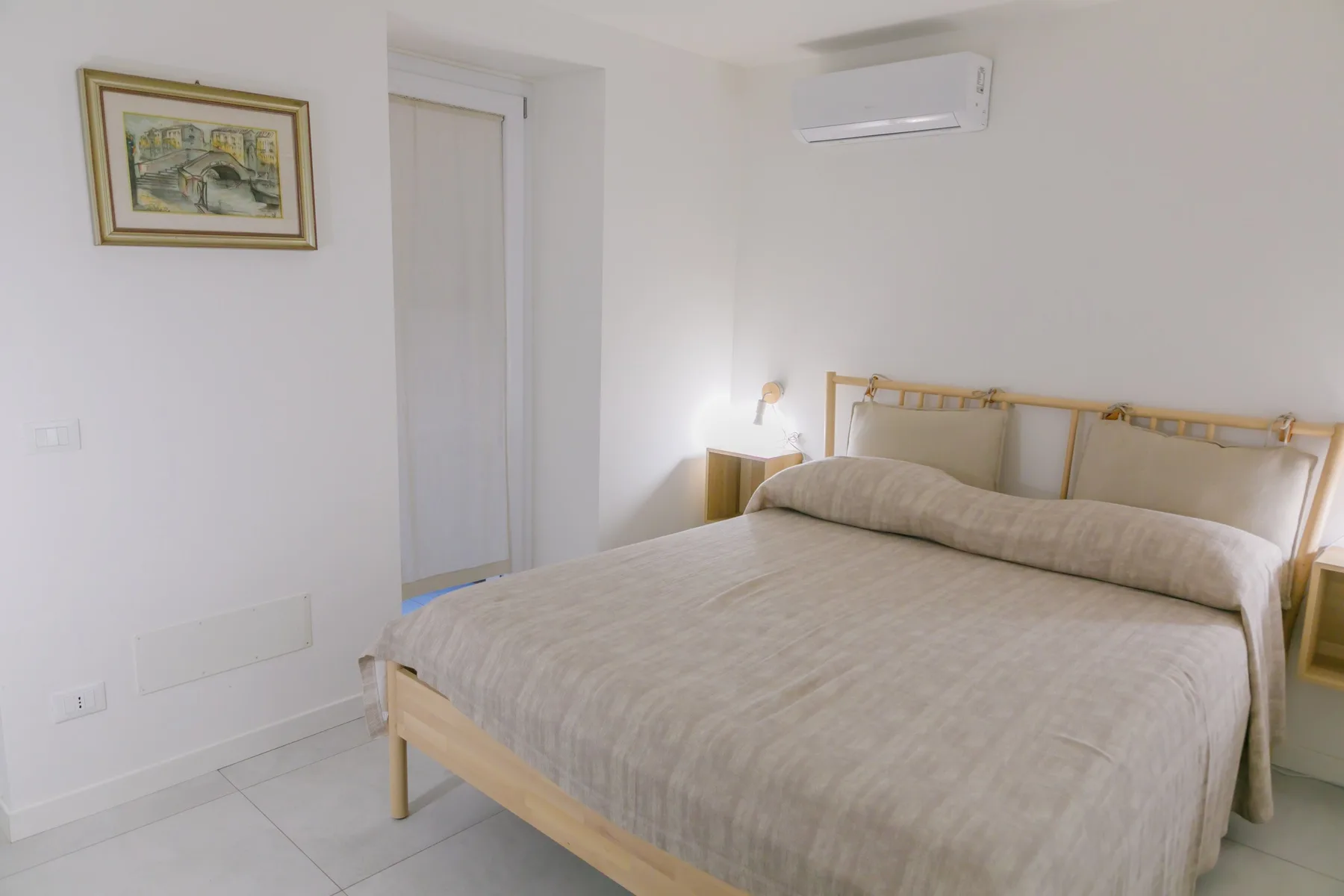 Un dormitorio con una cama grande y un aire acondicionado montado en la pared.
