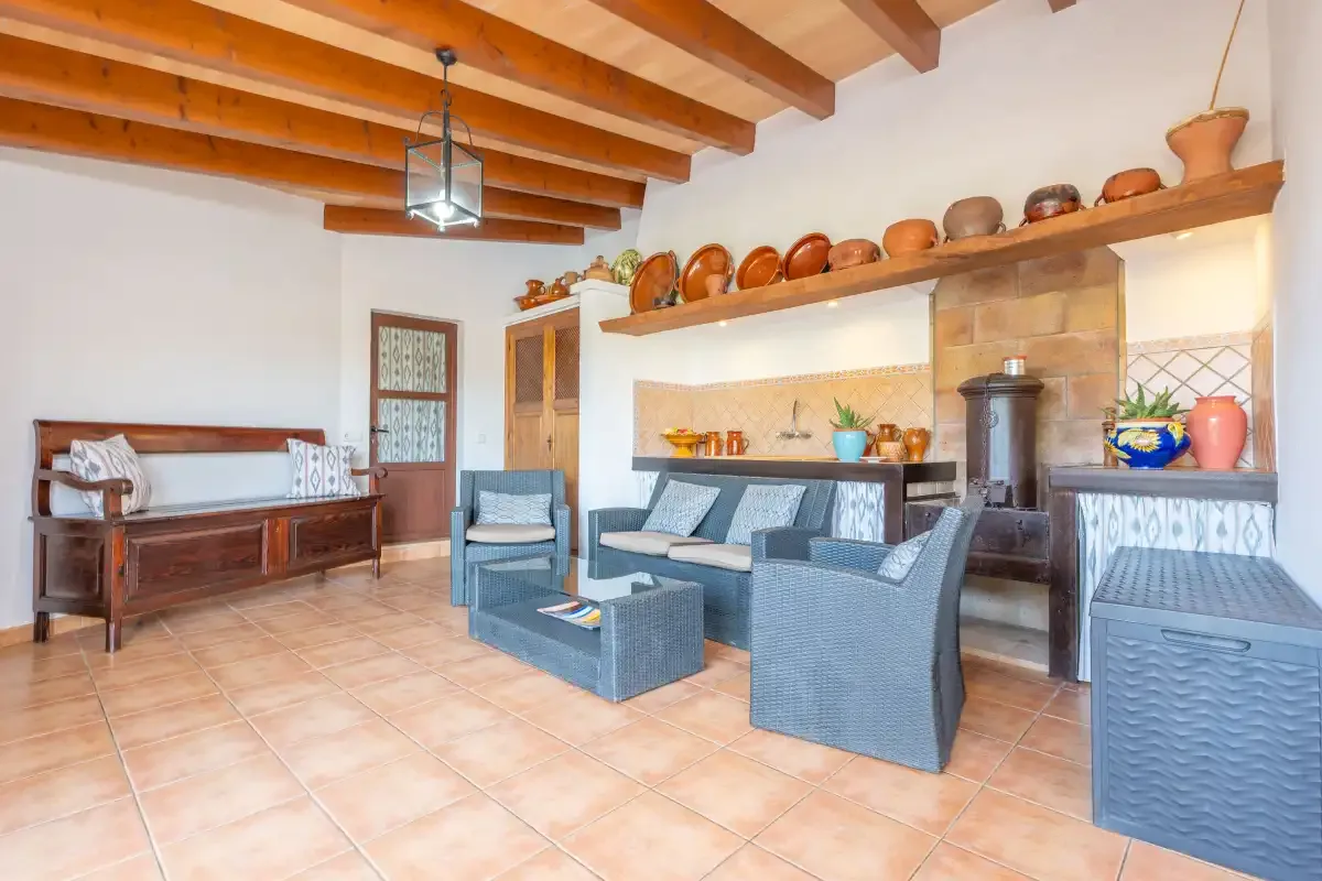 Una sala de estar con asientos alrededor de una mesa baja junto a una chimenea alicatada.