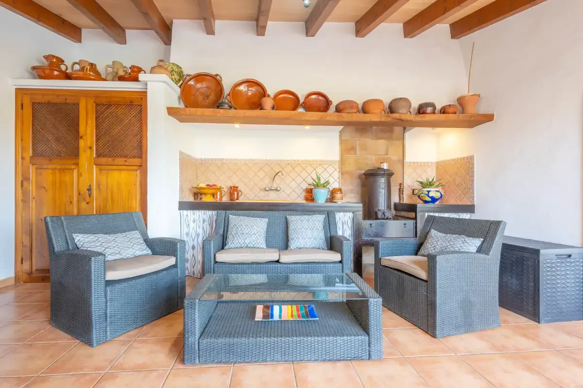 Una sala de estar con asientos tejidos y una mesa baja bajo vigas de madera vistas.