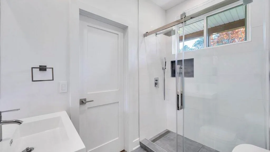 Un baño luminoso con lavabo y ducha de vidrio.