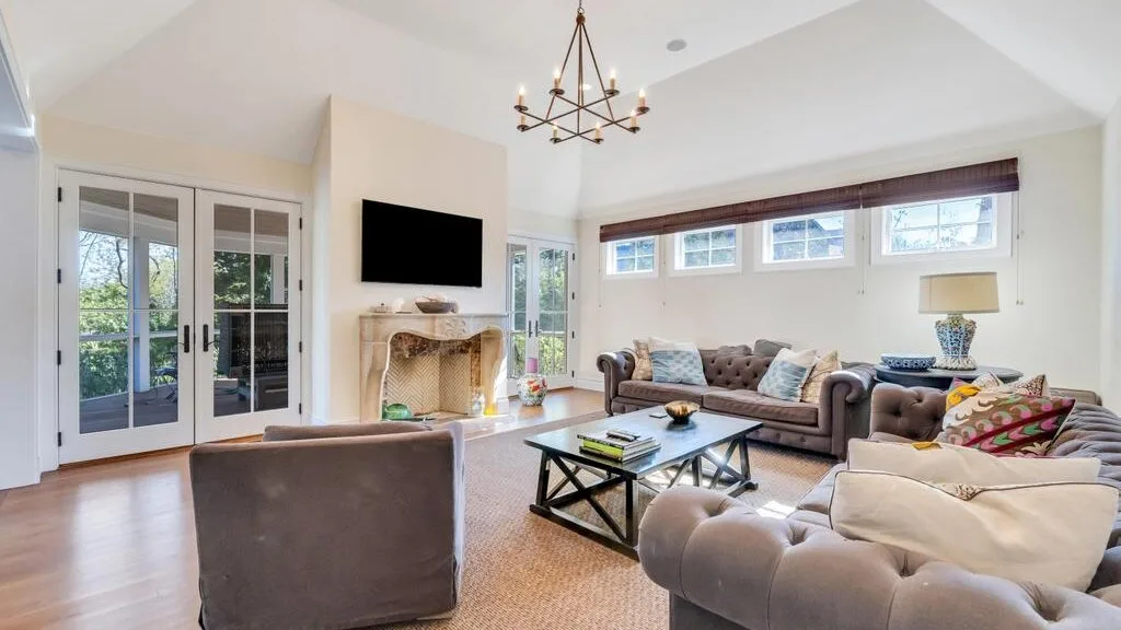 A bright living room with seating around a coffee table and a fireplace.