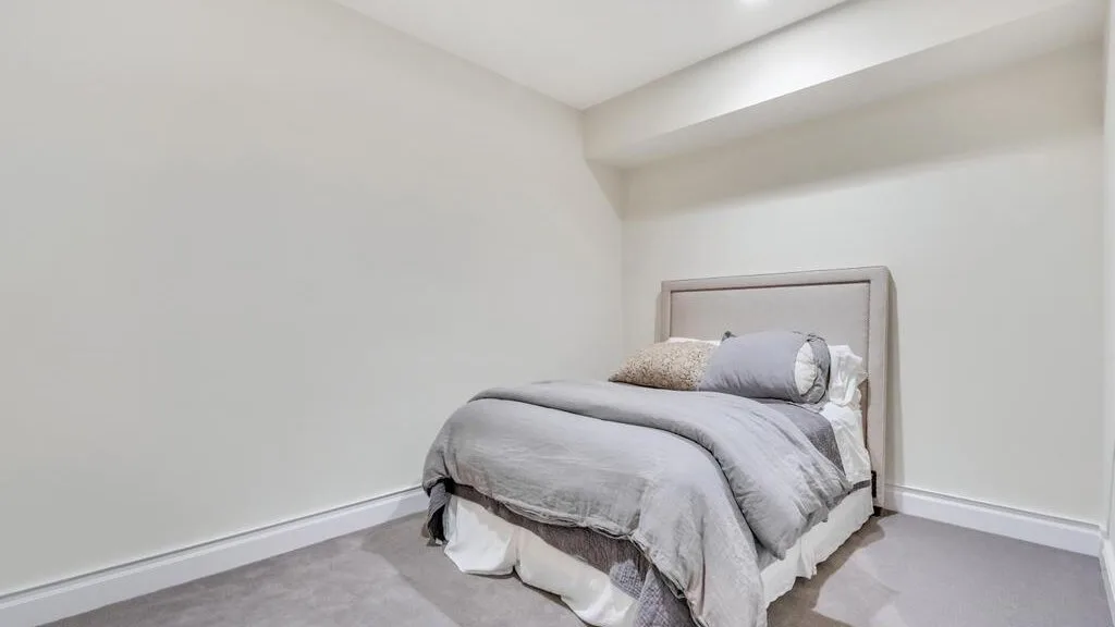 A simple bedroom with a bed dressed in gray bedding.