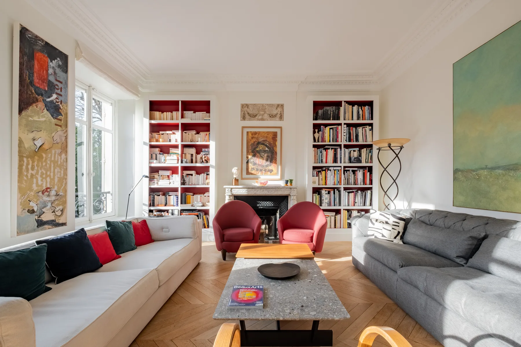 A bright living room with seating arranged around a coffee table and fireplace.
