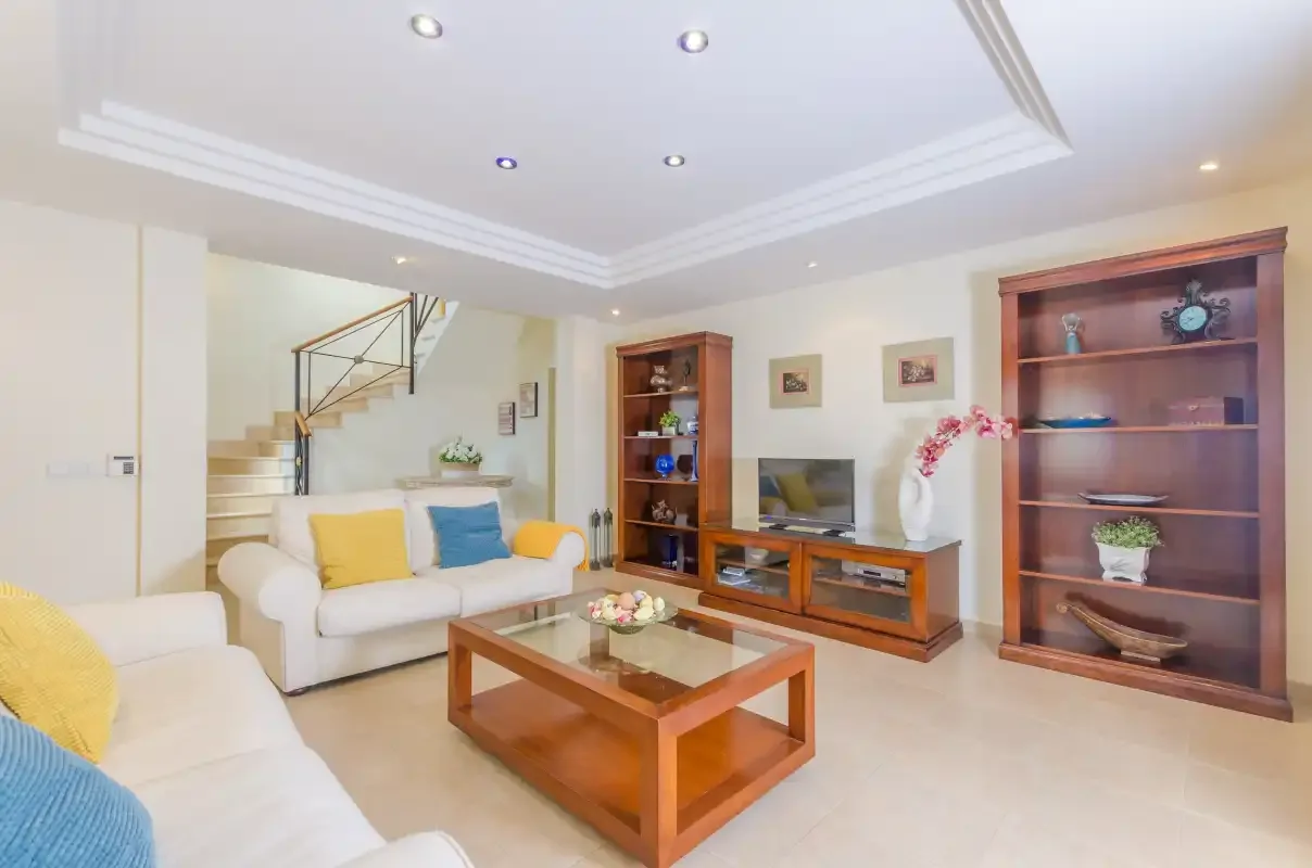 A living room with seating, a wooden coffee table, and built-in shelving.