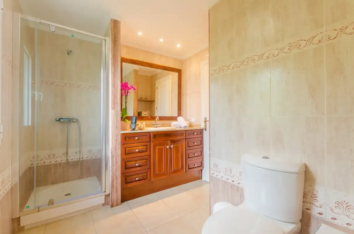 A tiled bathroom with a shower, vanity, and toilet.
