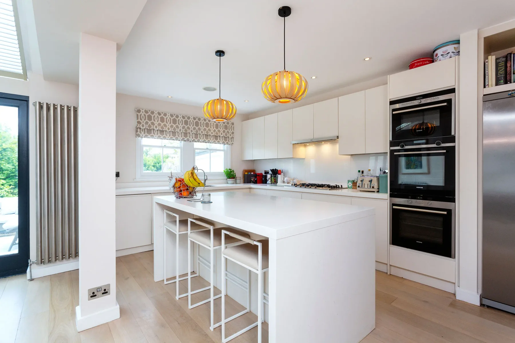 A bright modern kitchen with a large island and pendant lights.