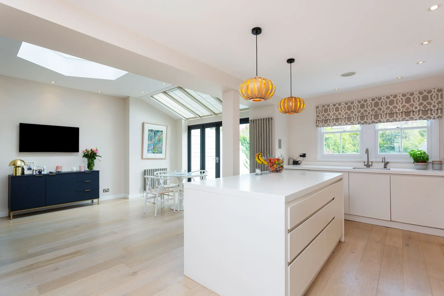 A bright open-plan kitchen and dining area with a large white island.