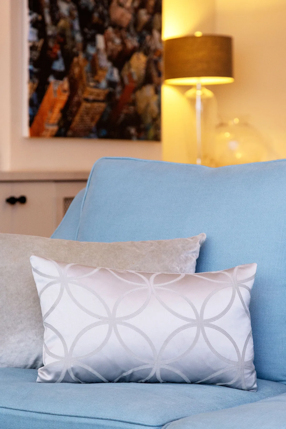 A living room seating area with a blue seat and patterned cushions.