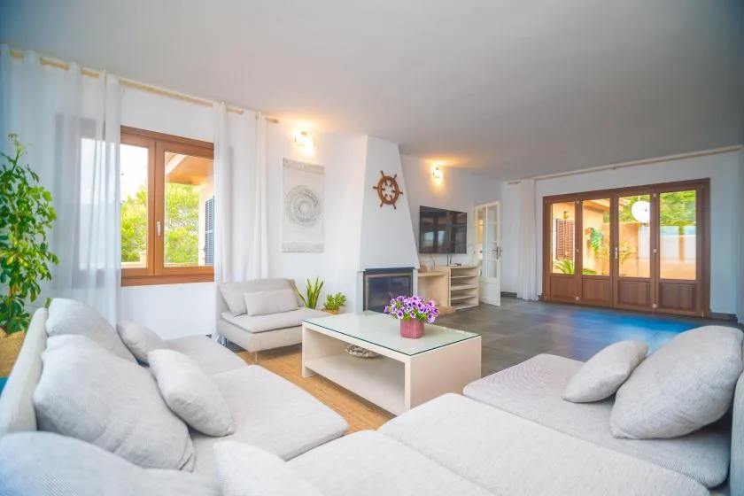A bright living room with light seating, a coffee table, and glass doors.