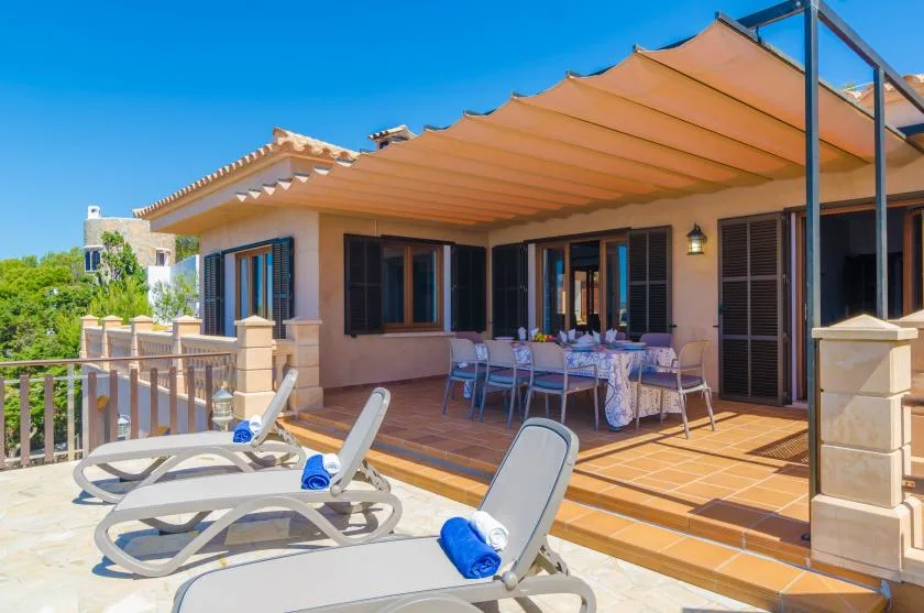 A sunny patio with lounge seating and a covered outdoor dining area.