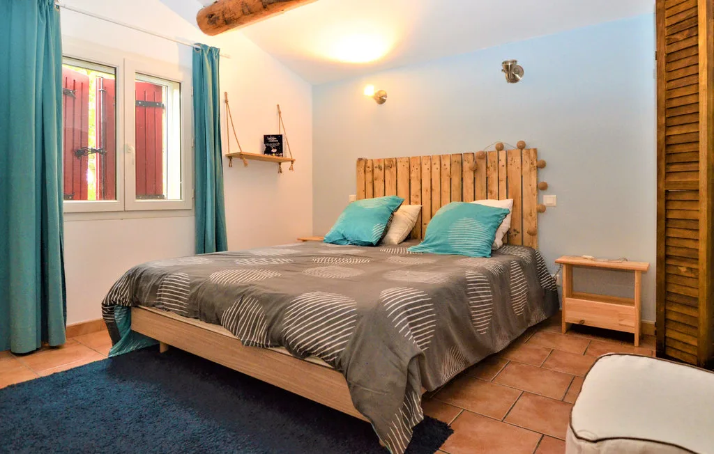 Un dormitorio con una cama doble, cortinas turquesas y una ventana.