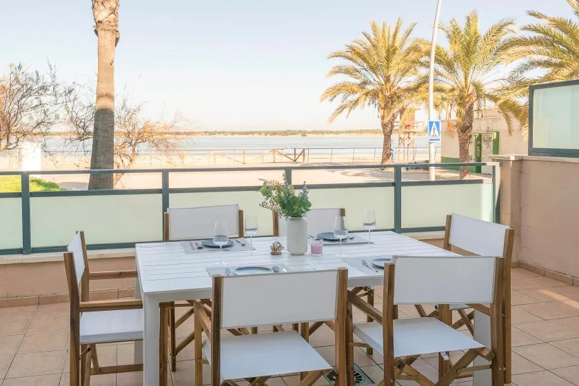 An outdoor dining area with a table and seating beside a waterfront.
