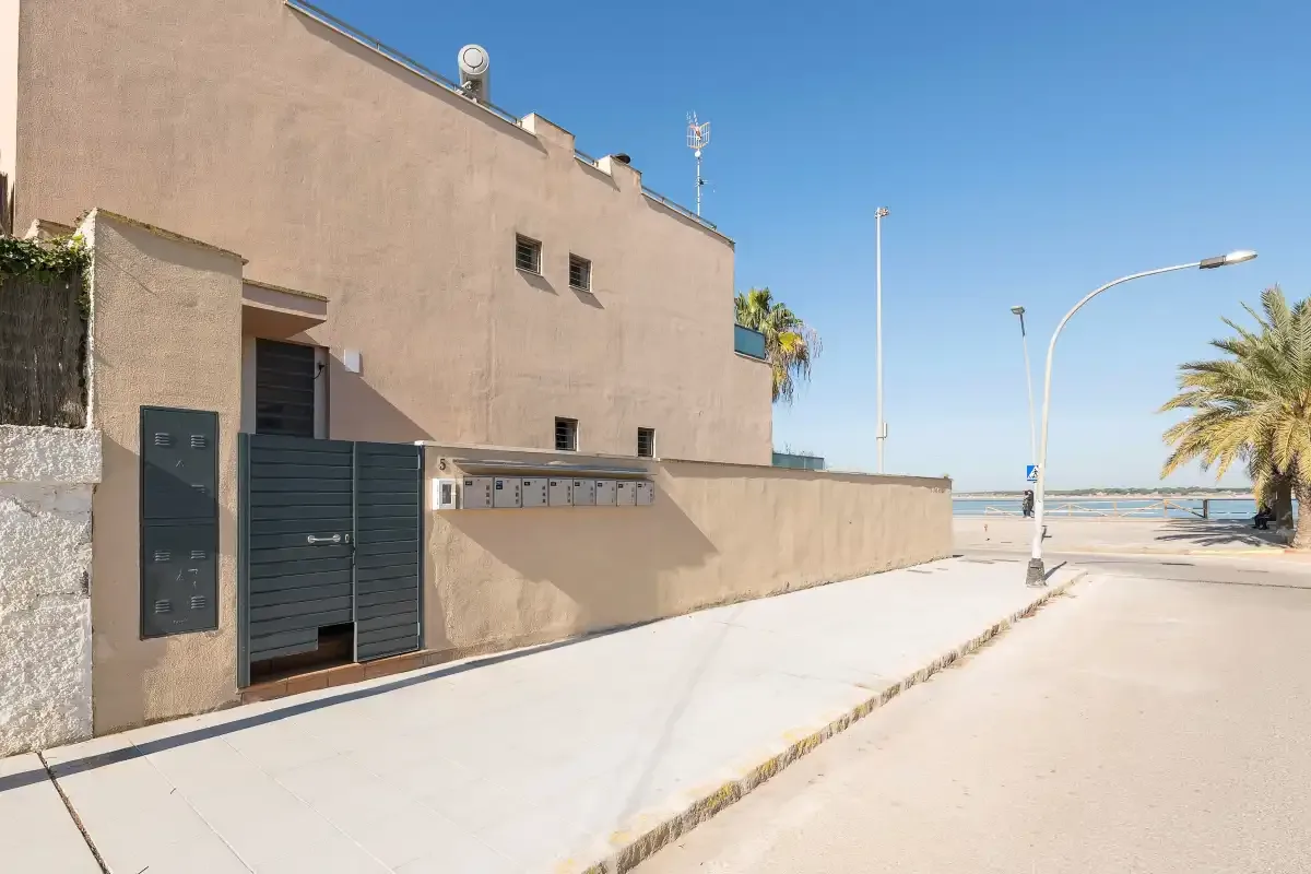 A modern building entrance beside a sunny seaside street.