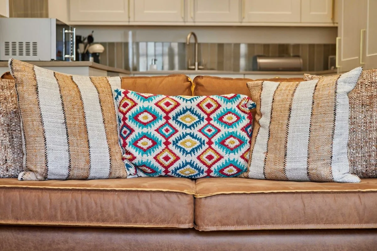 A living room seating area with patterned cushions on a sofa.