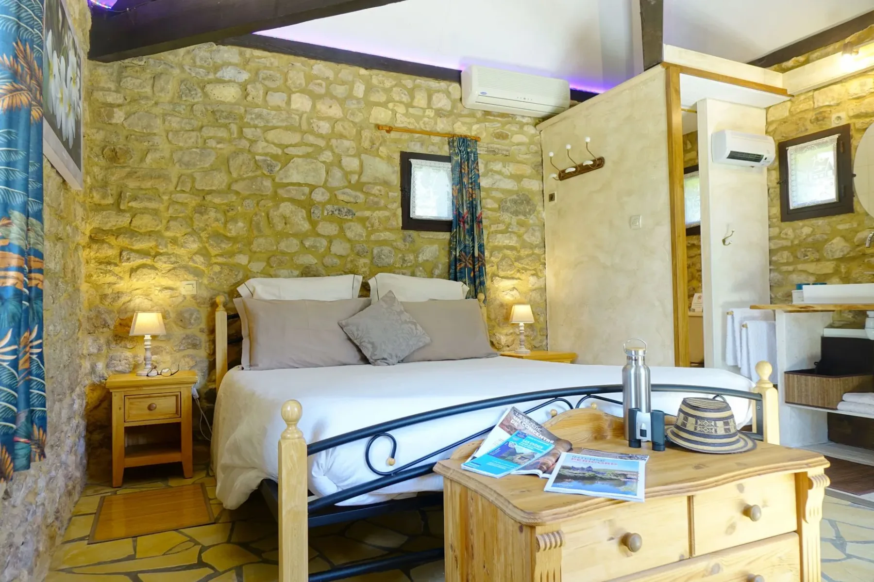 Interior de una habitación de huéspedes con cama, mesitas de noche, lámparas y una mesa de centro