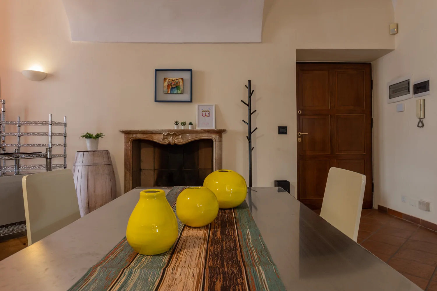 Un comedor con una mesa larga, sillas y una chimenea.
