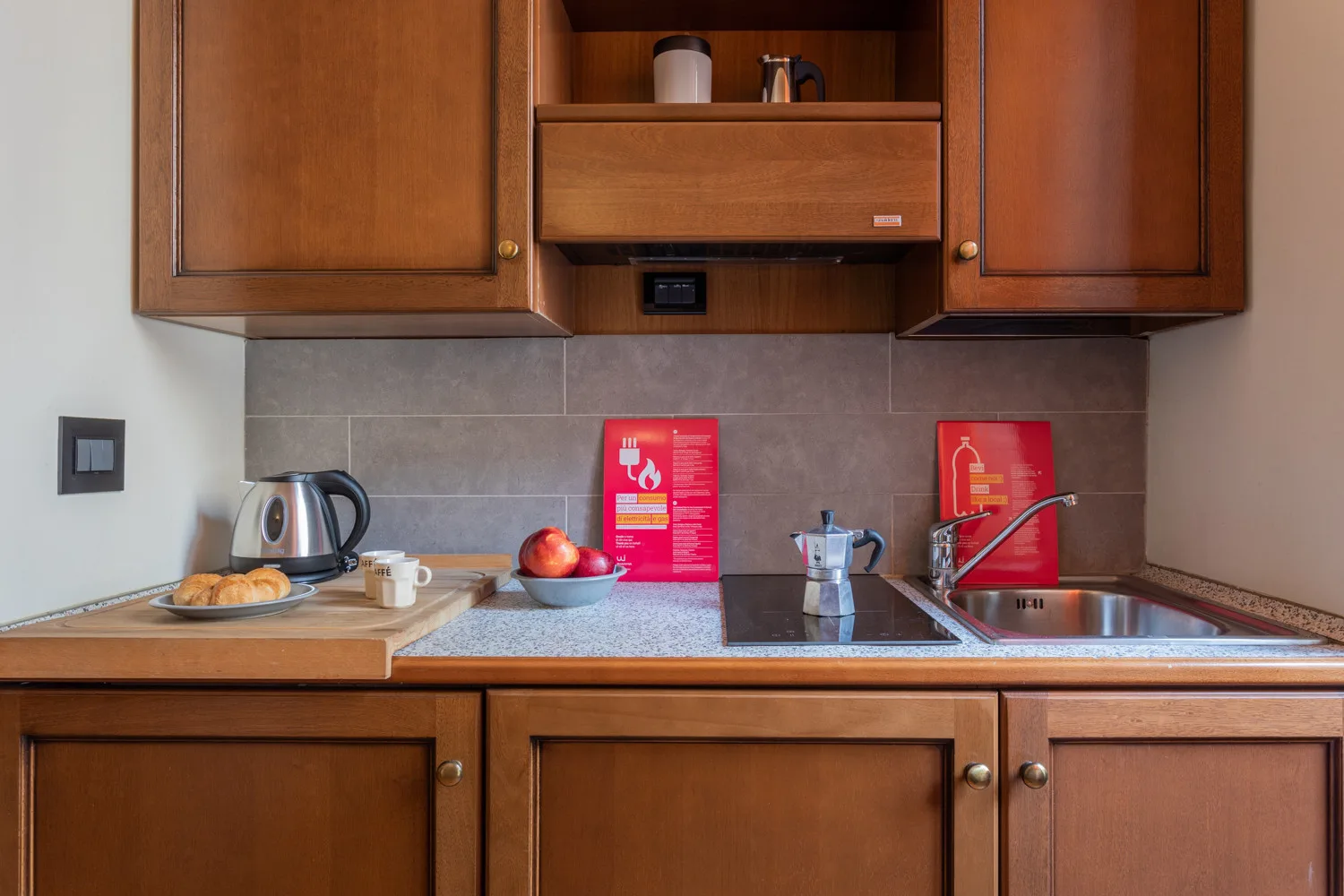 Una cocina compacta con gabinetes de madera, una encimera y un fregadero.