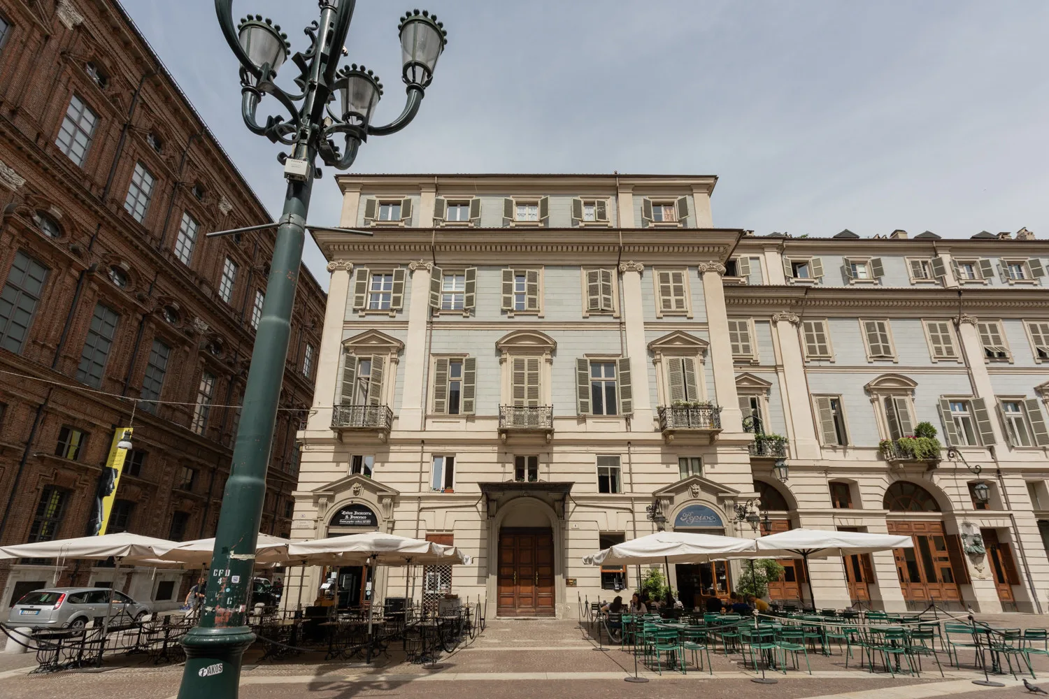 A historic-looking building with outdoor café seating along the street.