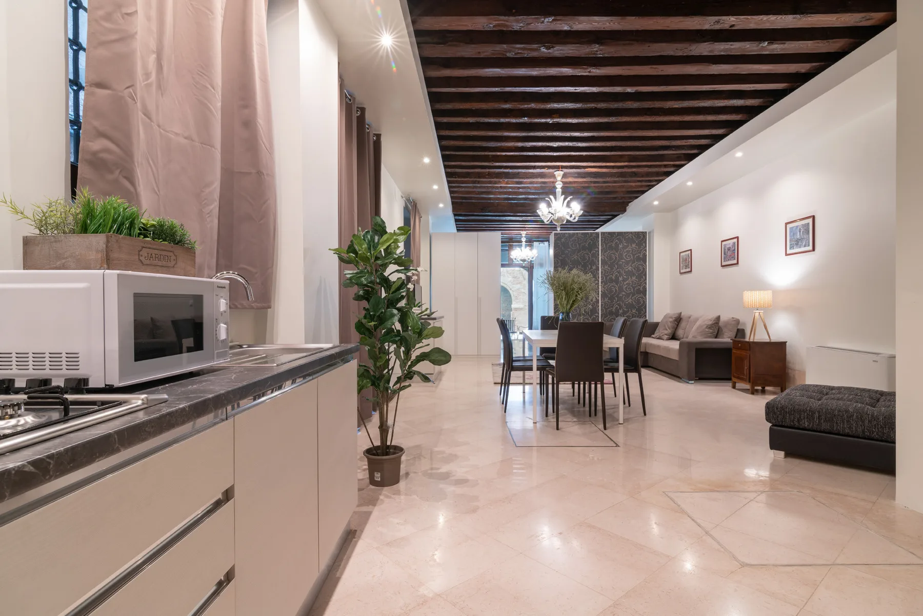 Una sala-comedor de planta abierta con una barra de cocina y asientos.