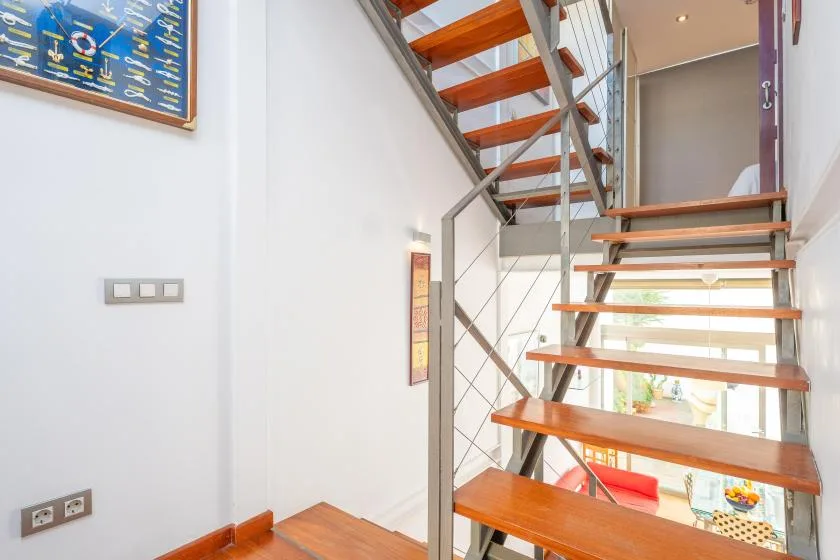 An open staircase with wooden treads and metal railings leads to an upper level.