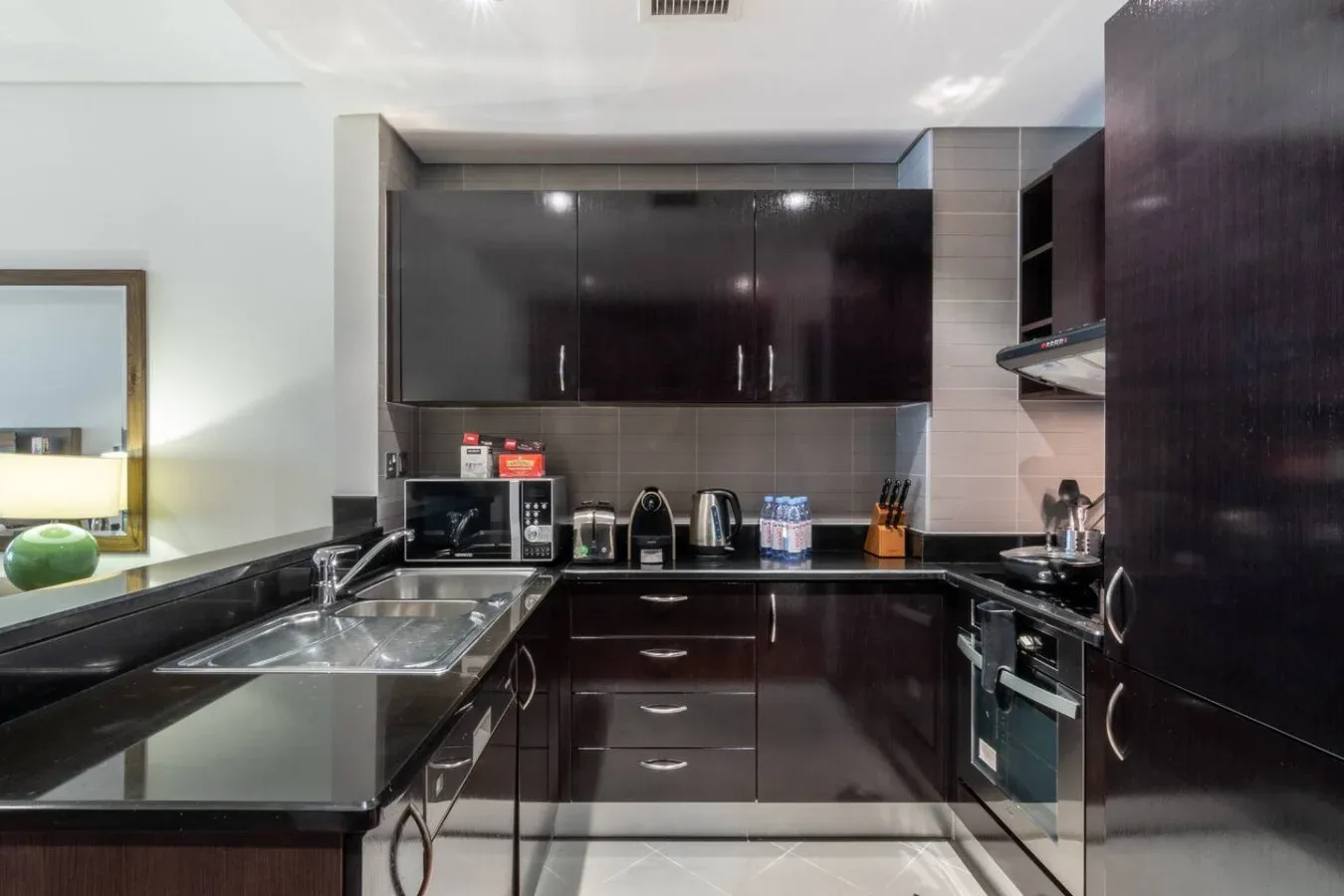 Una cocina moderna con gabinetes oscuros, una encimera y electrodomésticos integrados.