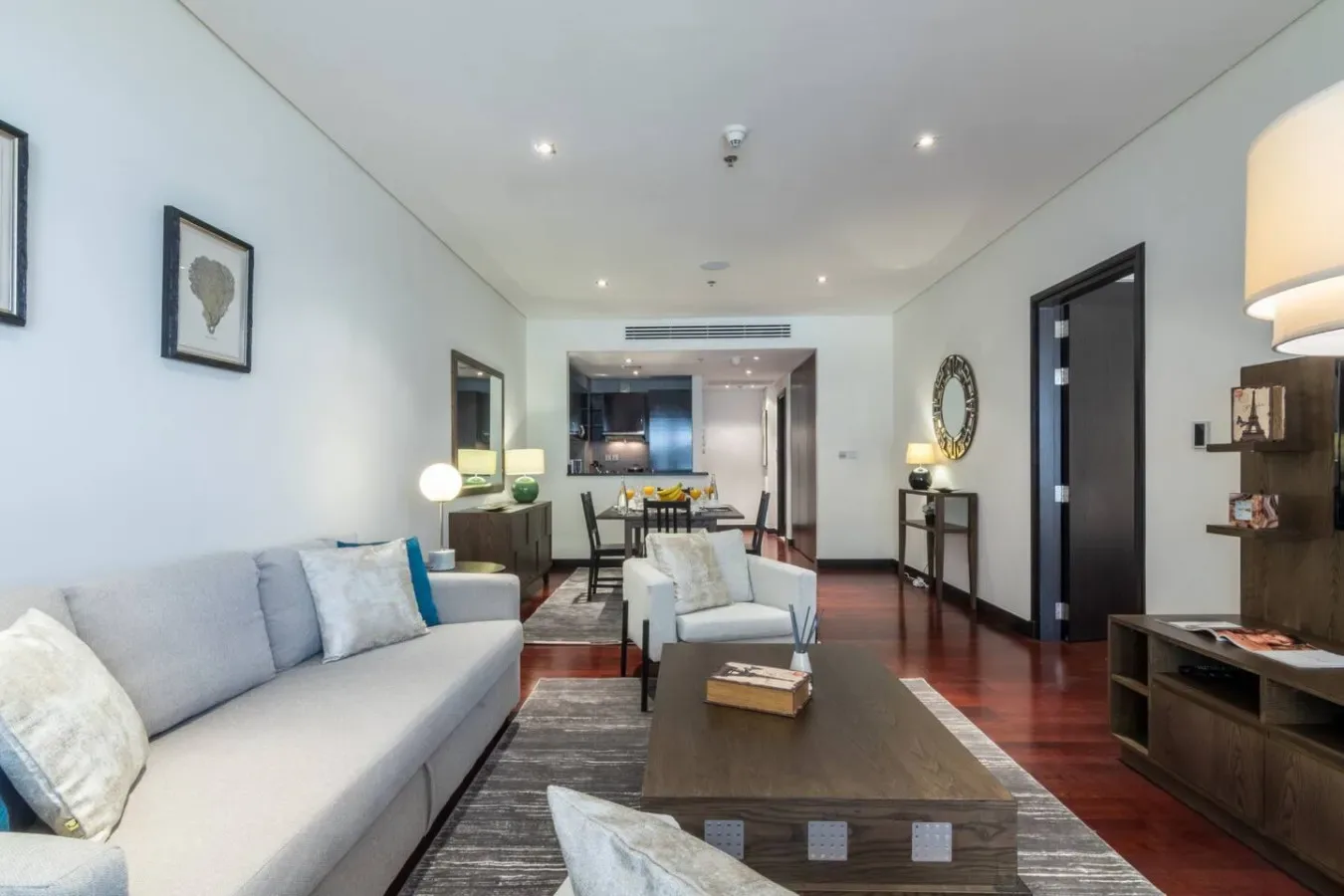 Una sala moderna se abre a un comedor, con un sofá y una mesa de centro.