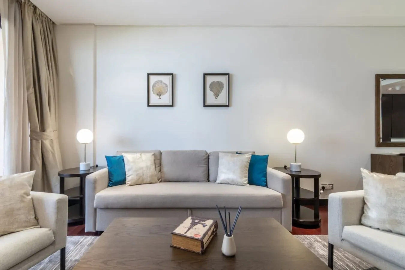 Una sala de estar con un sofá gris, sillones a juego y una mesa de centro.