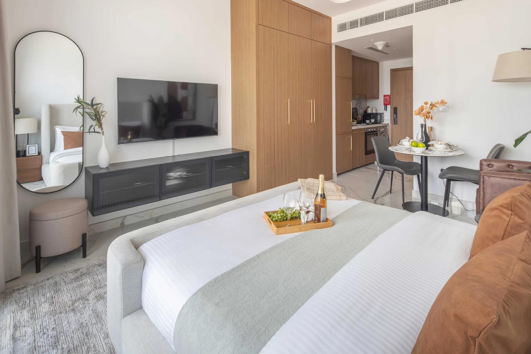 Un dormitorio con cama, televisor en la pared y zona de comedor.