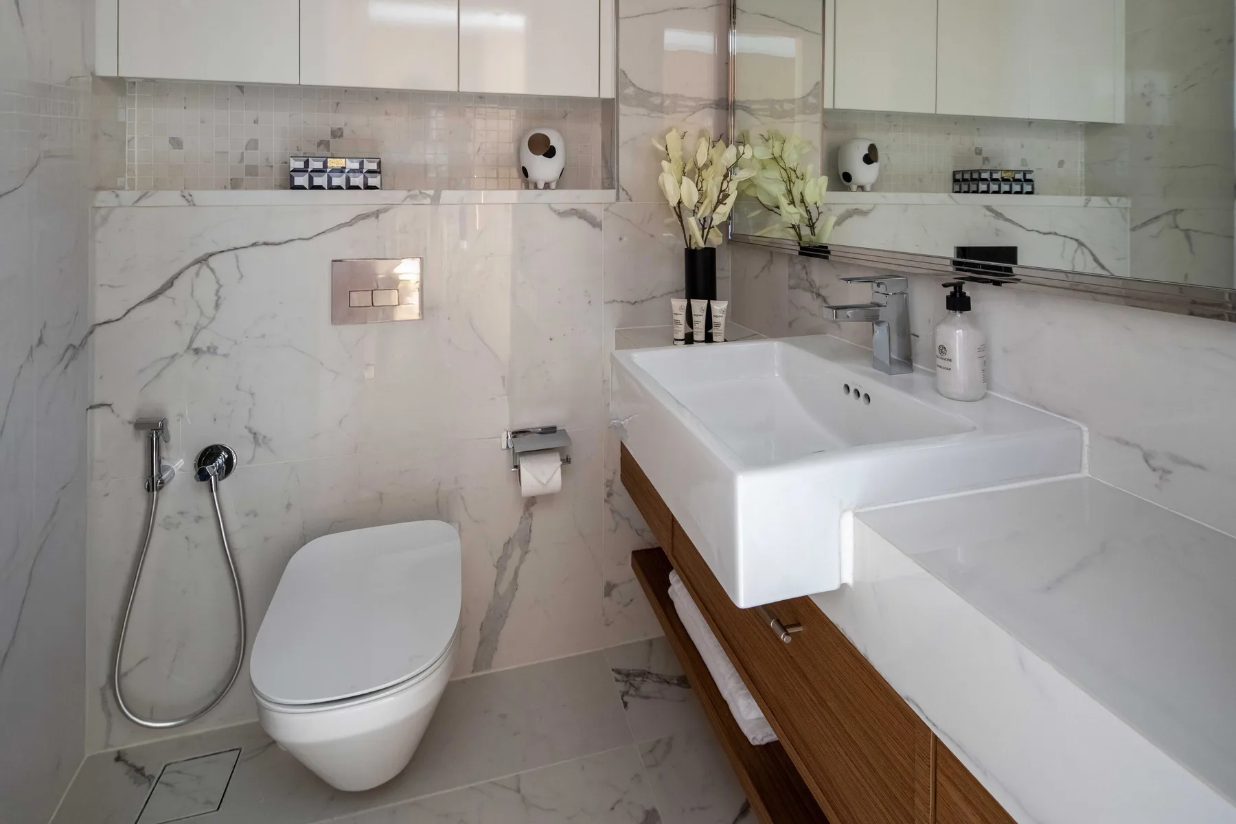 A marble bathroom with a toilet, sink, and bathtub.