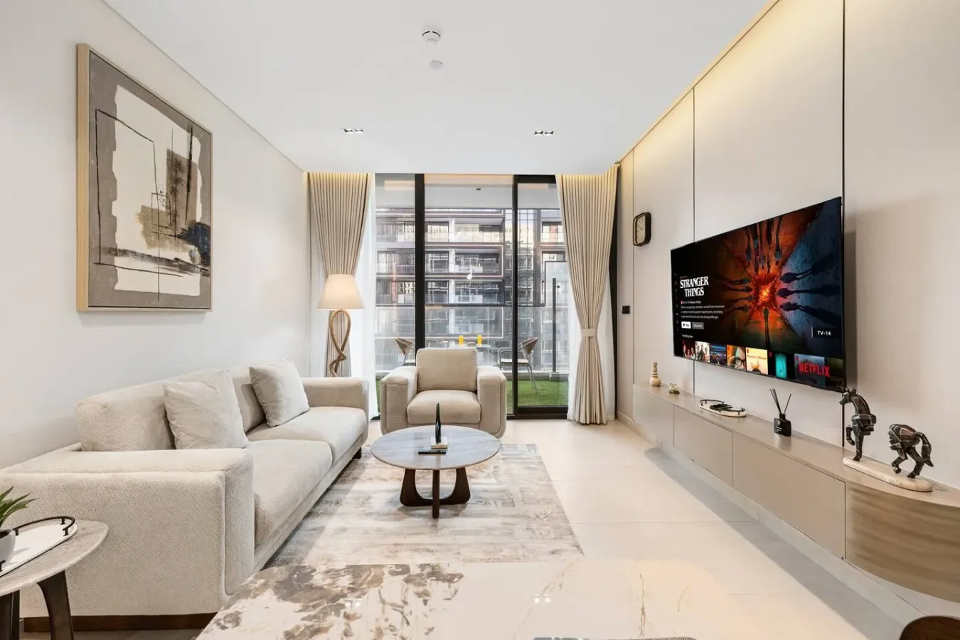 Una sala luminosa con asientos, una mesa de centro y un televisor.