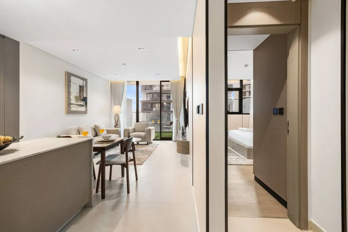 Una luminosa sala con comedor se abre hacia grandes ventanas y un balcón.