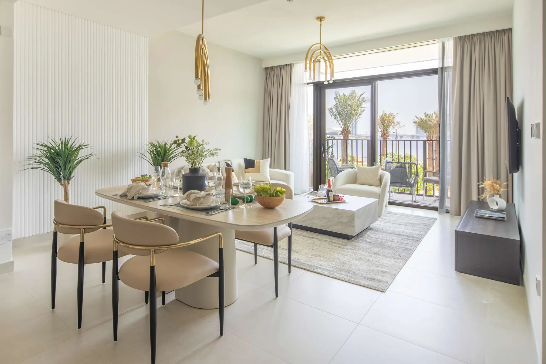 A bright dining and living area with a table, seating, and large glass doors.