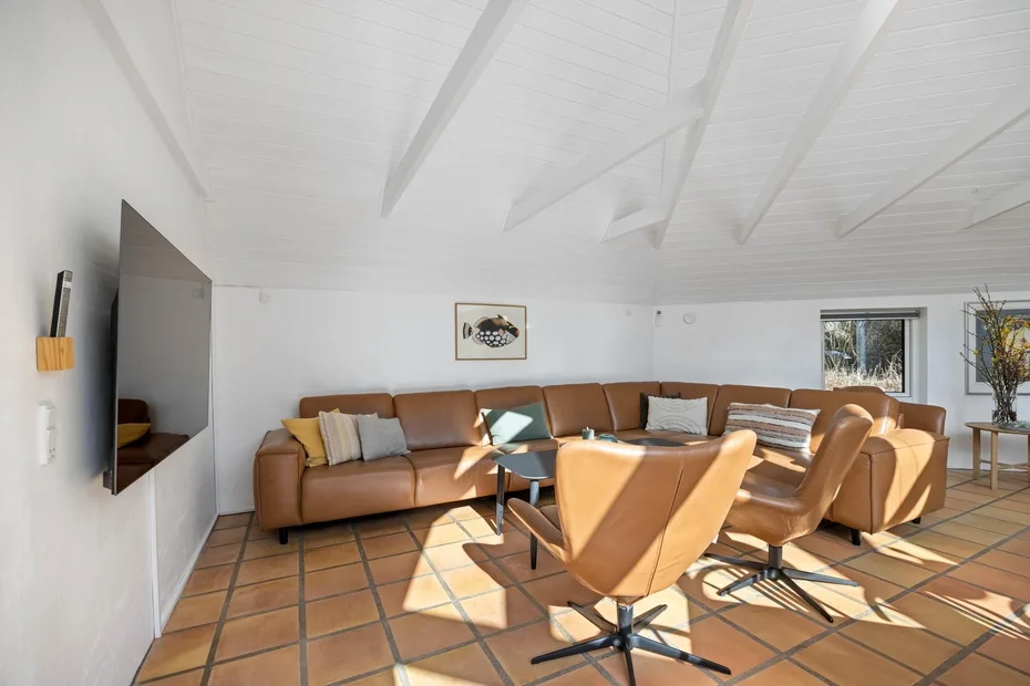 Una sala luminosa con asientos color canela alrededor de una mesa baja.